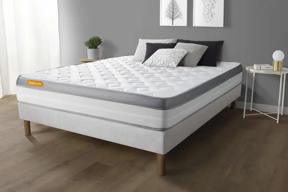Matelas matelassé sur un cadre de lit en bois clair